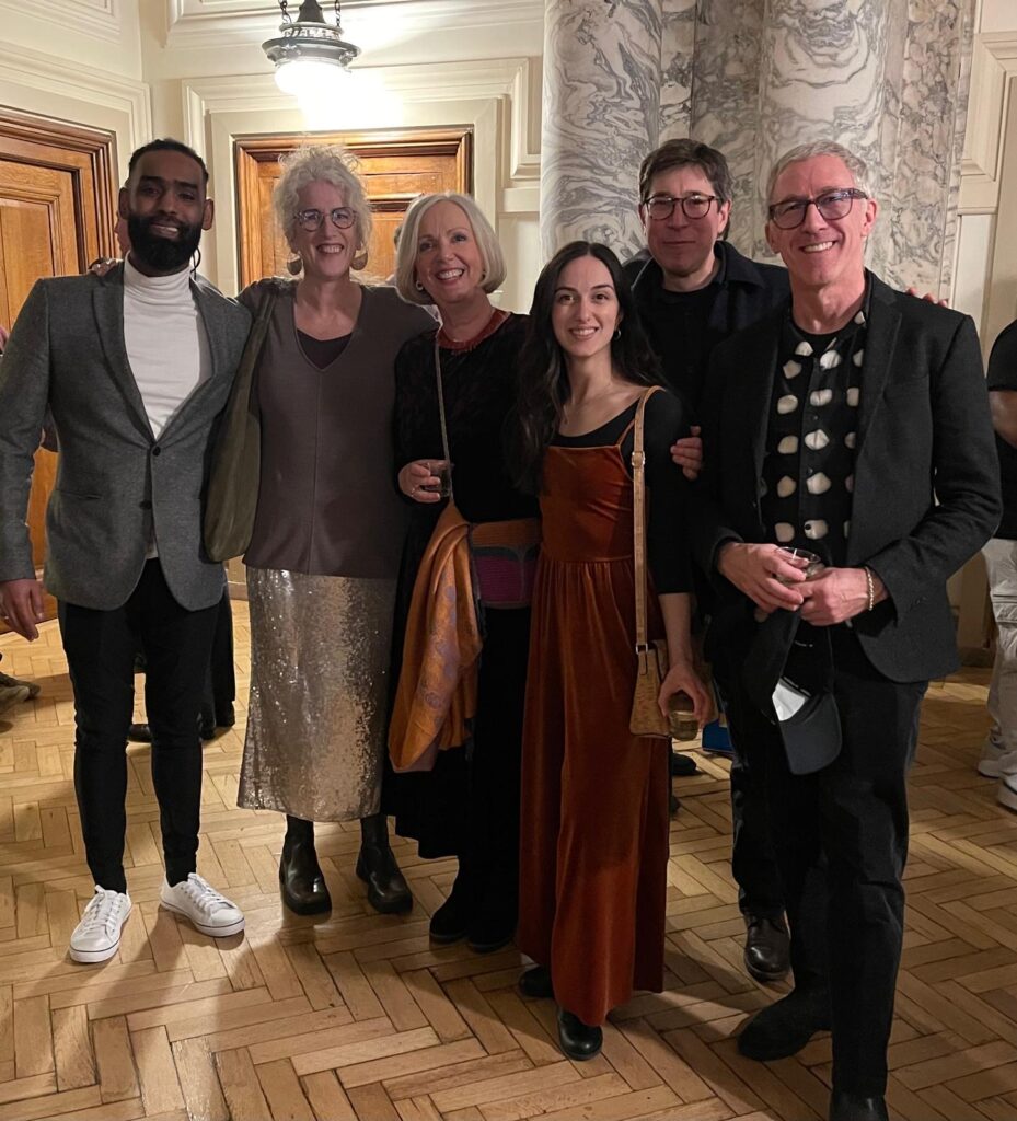a group of people, 3 men and 3 women stand smiling into camera at an awards event